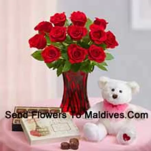 12 Red Roses With Some Ferns In A Glass Vase, A Cute 12 Inches Tall White Teddy Bear And An Imported Box Of Chocolates