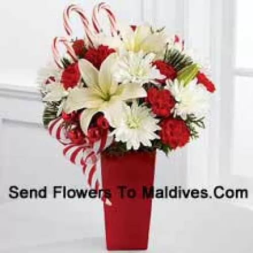 Bursts with the bright cheer and jubilant beauty of this special season. White Asiatic Lilies and chrysanthemums sit amongst red mini carnations, assorted holiday greens, red glass balls, three candy canes and festive ribbon, perfectly arranged in a red ceramic vase to create a lively bouquet of merry wishes for a splendid holiday season! (Please Note That We Reserve The Right To Substitute Any Product With A Suitable Product Of Equal Value In Case Of Non-Availability Of A Certain Product)